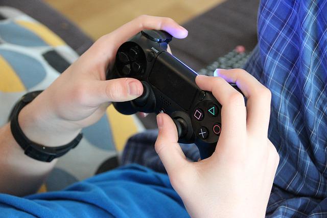 Child's hands playing video game. 